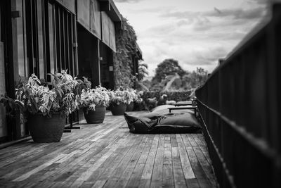 Woman relaxing on wooden floor against sky