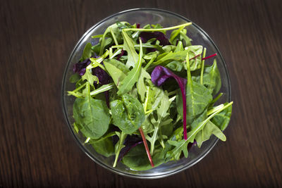 Mixed leaves of a diet salad on a wooden table. a view from above