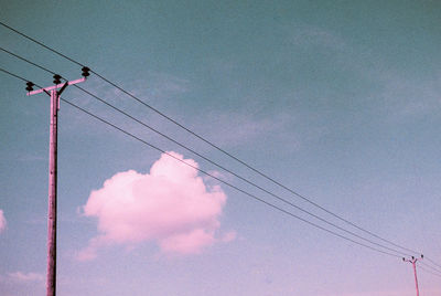 Low angle view of electricity pylon against sky during sunset