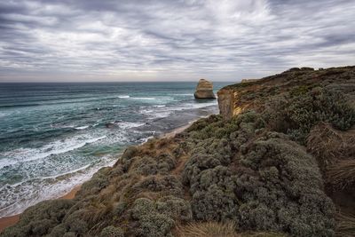 Scenic view of sea and cliff against sky