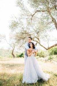 Newly married couple embracing outdoors