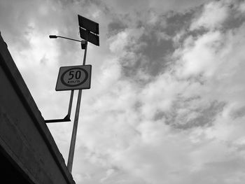 Low angle view of road sign against sky