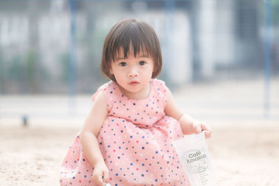 Portrait of cute girl holding pink outdoors