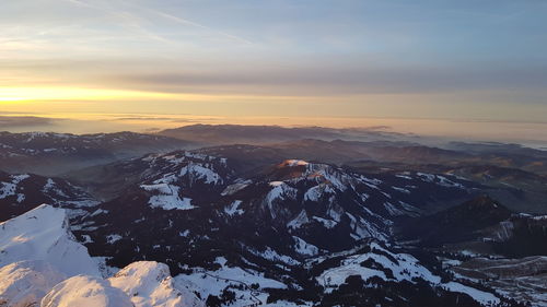 Scenic view of snowcapped mountains against sky during sunset