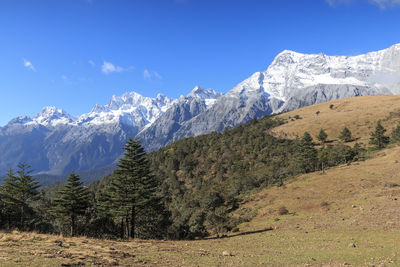 Scenic view of mountains against blue sky