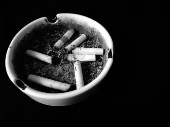 Close-up of cigarette smoking against black background