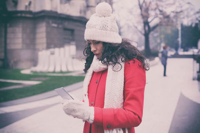 Close-up of woman with mobile phone while standing on snow