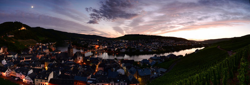 High angle view of river amidst buildings against sky at sunset