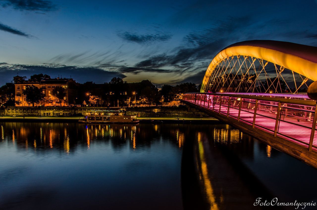 REFLECTION OF ILLUMINATED BRIDGE AT NIGHT