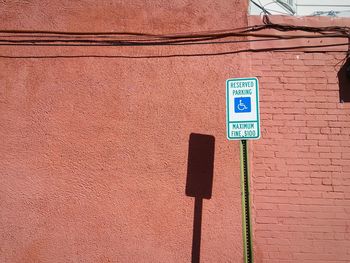 Information road sign by brown wall