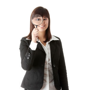 Portrait of young woman standing against white background