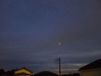 Low angle view of silhouette electricity pylon against sky at sunset