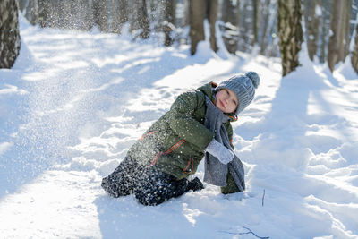 Side view of woman skiing on snow covered field