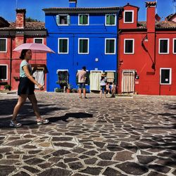 People walking on street against buildings in city