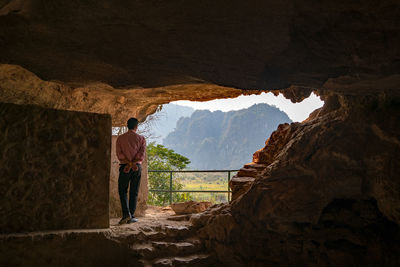 Rear view of man standing in cave