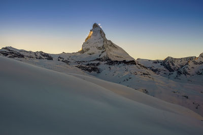 Scenic view of snowcapped mountains against clear sky