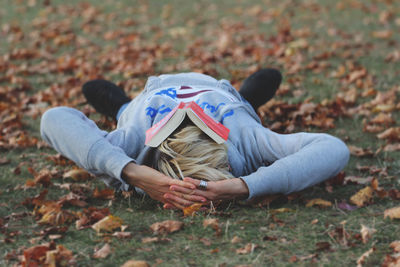 Woman lying down on field during autumn