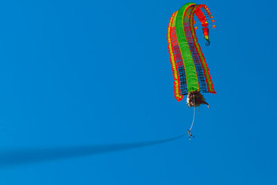 Low angle view of kite flying against clear blue sky