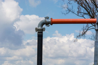 Low angle view of metallic pipe against sky