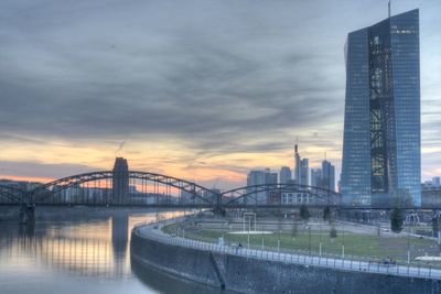 Bridge over river against cloudy sky