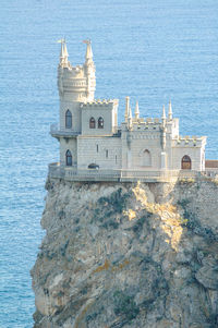 Buildings by sea against sky