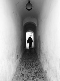 Rear view of people walking in tunnel