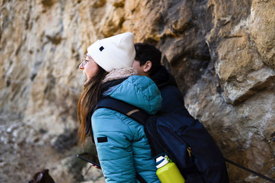 Mother and son wearing warm clothes shouting on a mountain