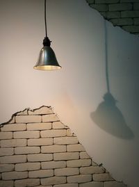 Low angle view of illuminated lamp hanging on wall