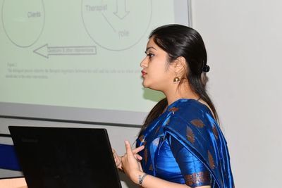 Side view of young woman using mobile phone