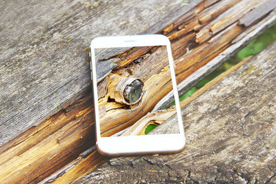 High angel view of mobile phone on wood