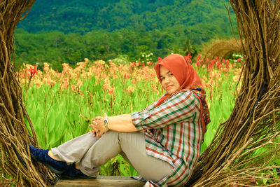Portrait of a smiling woman sitting on grassland