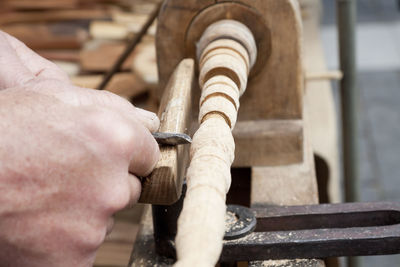 Cropped hands of carpenter carving wood at workshop