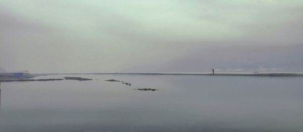 Scenic view of lake against cloudy sky