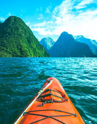 Scenic view of sea by mountains against sky