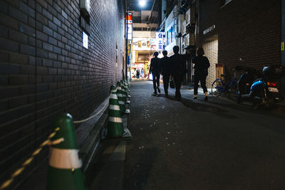 People walking along alley at night 