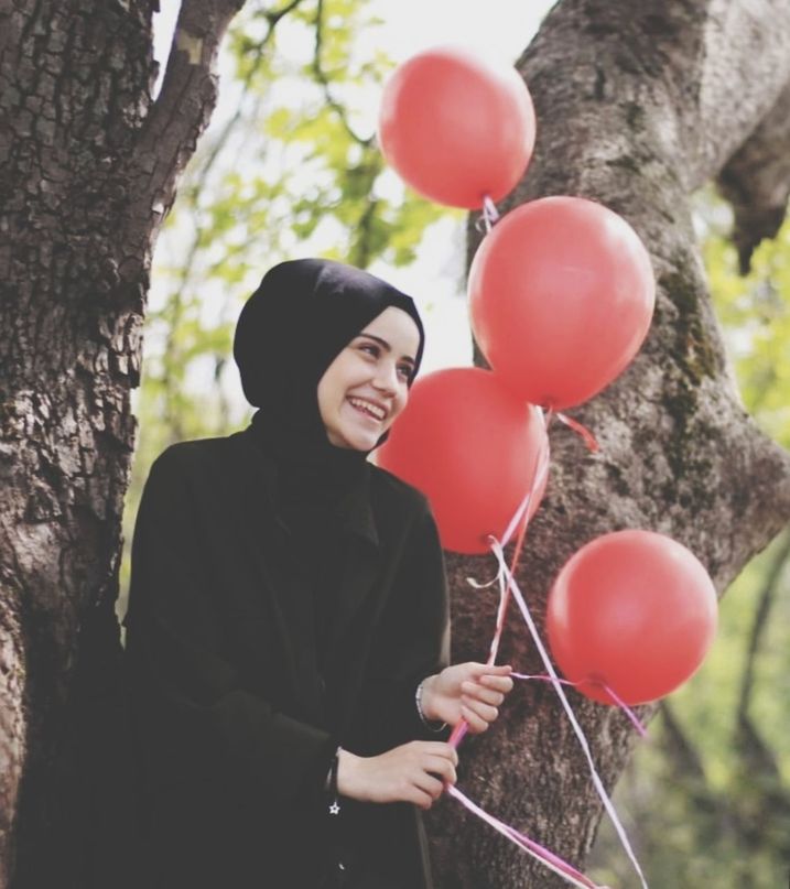 balloon, smiling, tree, one person, happiness, young adult, women, holding, plant, emotion, real people, nature, tree trunk, young women, trunk, day, adult, lifestyles, standing, outdoors, hairstyle
