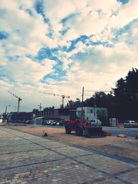 Cars on street in city against sky