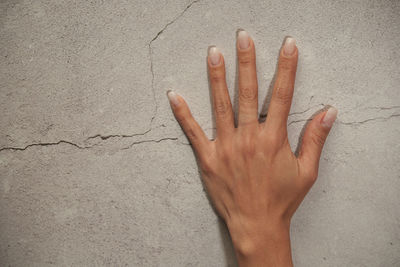 Close-up of human hand against wall