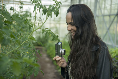 Young woman standing by plants