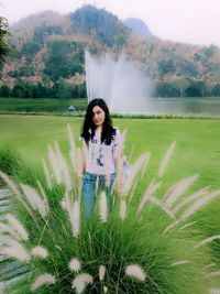 Portrait of young woman standing on field