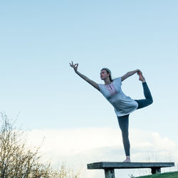 Low angle view of woman standing against sky