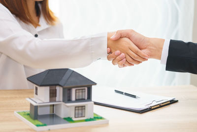 Cropped image of woman with text on table in building