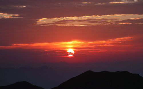 Scenic view of silhouette mountains against romantic sky at sunset