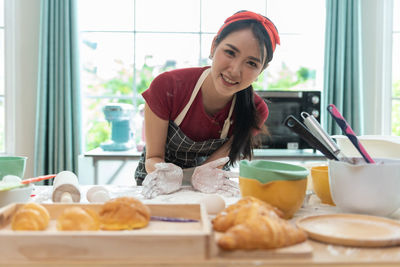 Portrait of young woman preparing food at home