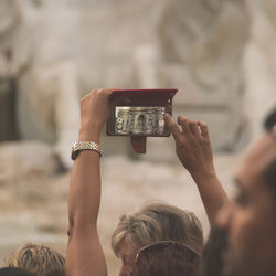 Cropped image of woman photographing historic building