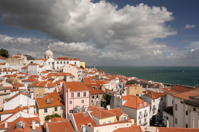 High angle view of townscape by sea against sky