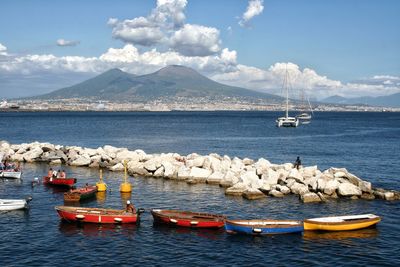 Sailboats moored on sea against sky