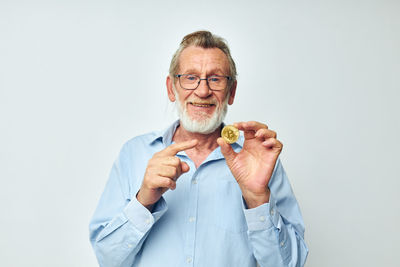 Portrait of young man holding food against white background