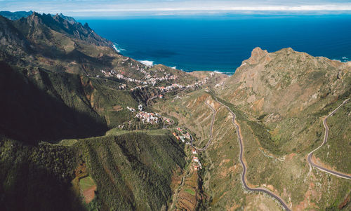 High angle view of sea and mountains against sky