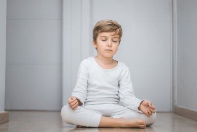 Full length of a boy sitting on floor at home